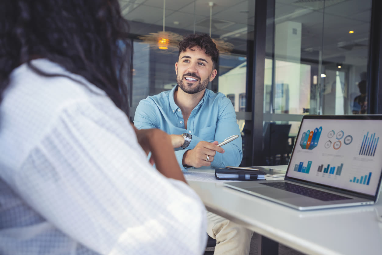 Owner smiling across the table during a one-on-one meeting
